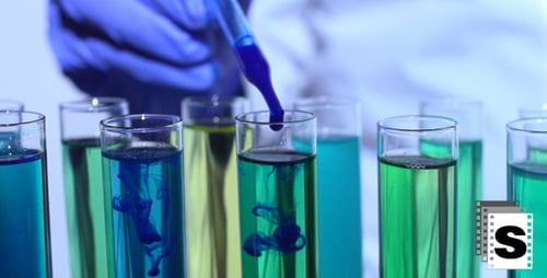 Blue Pipette Drops Liquid into Colorful Test Tubes