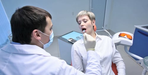 Dentist Examining Patient's Teeth in Bright Clinic