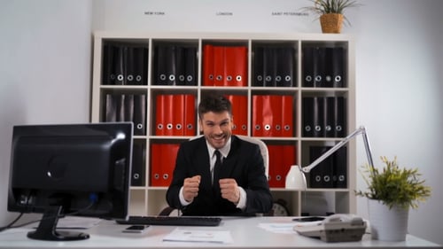 Man Smiling at Office Desk Working