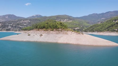 Beautiful mountain lake with clear green water and large stones on shore aerial view