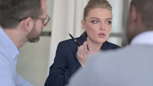 Rear View of Young Businesswoman Talking to Male Colleagues