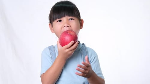 Happy little girl with apple.