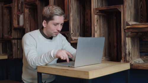 Young Man Using Laptop in the Cafe