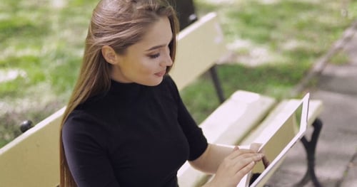 Woman Using Tablet on Park Bench