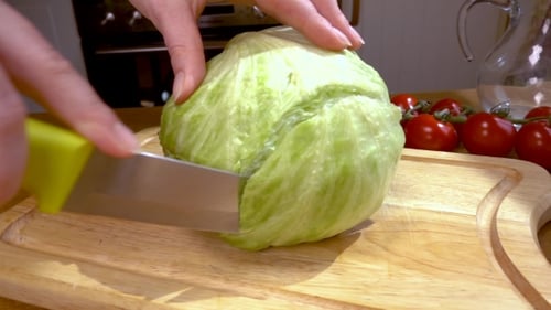 Cutting Iceberg Lettuce on Wooden Cutting Board