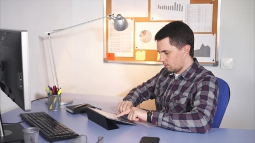 Trabalhador de escritório digitando no tablet e pensando.