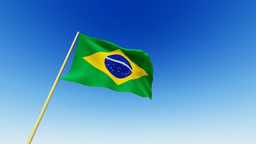 Waving Flag of Brazil Against a Clear Blue Sky