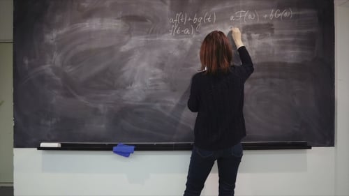 Woman Writing Math Equations on Chalkboard