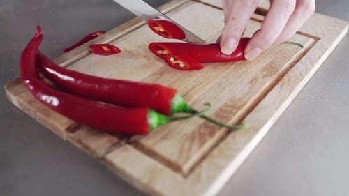 Slicing a Red Chili Pepper on Cutting Board