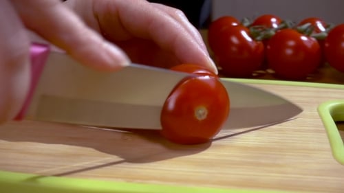 Tomato Sliced with Knife on Cutting Board