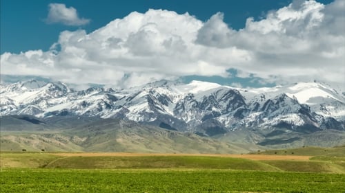 Paysage avec des sommets montagneux et un ciel nuageux