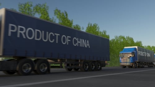 Moving Freight Semi Trucks with PRODUCT OF CHINA Caption on the Trailer