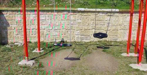 Swings Moving Gently on the Playground