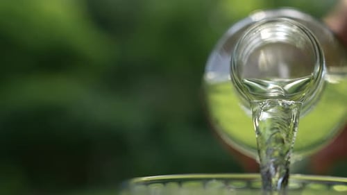 Water Pouring From Bottle Into Glass Close Up