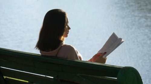 Woman Reads a Book in a Sunny Park