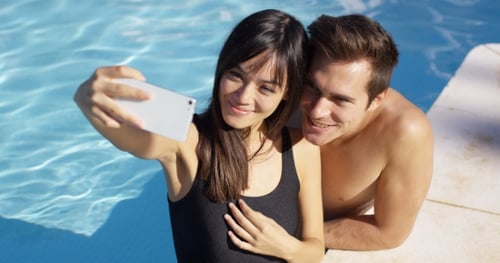 Handsome Couple Take Photo While Standing in Pool