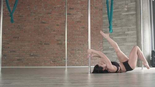 Athletic Woman Does Pole Exercises in Studio