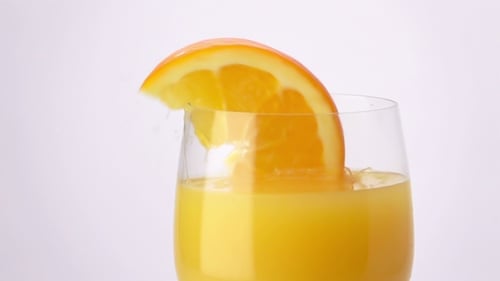 Orange Segment Dropped into Glass of Juice