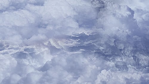 Durch Wolken über den Bergen fliegen