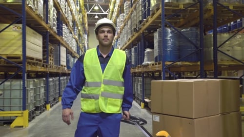 Cheerful Warehouse Worker Moves Cart with Boxes