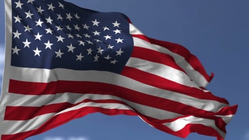 Seamless Loop of Waving American Flag Against Blue Sky