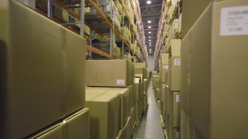 Camera Moves Along Boxes in Warehouse