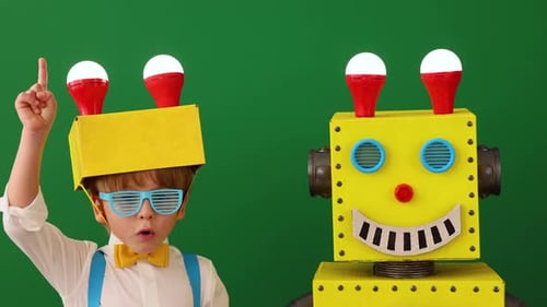 Boy With Cardboard Robot Friend on Green Background