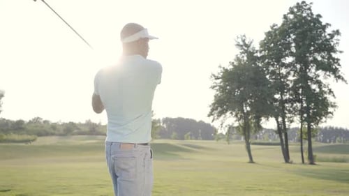 Man Swinging Golf Club on Beautiful Green