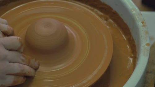 Potter Shaping Clay on a Spinning Wheel