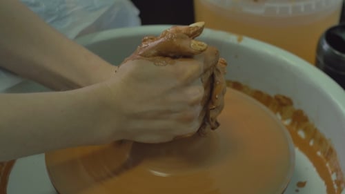 Potter's Hands Shaping Clay on Wheel