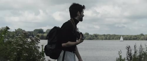 Man taking pictures of the lake and smiling
