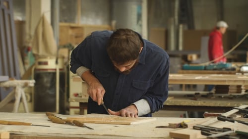 Woodworker Carefully Carving Intricate Design in Wood