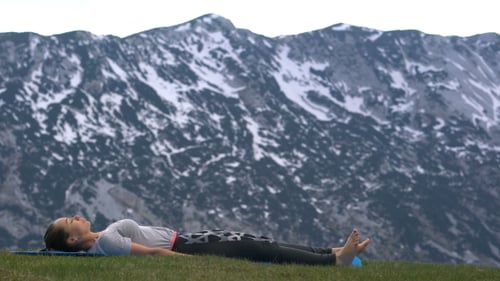 Woman Exercising and Stretching Outdoors with Mountain Backdrop