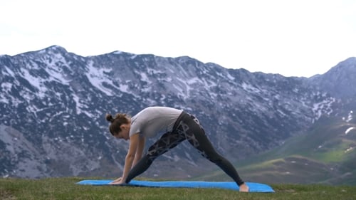 Woman Practices Yoga Outdoors In Mountain Setting