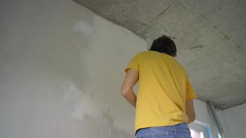 Man renovating wall in apartment