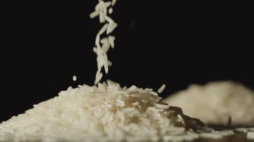 SLOW MOTION: White Rice Grains Pouring Onto A Table - Close Up