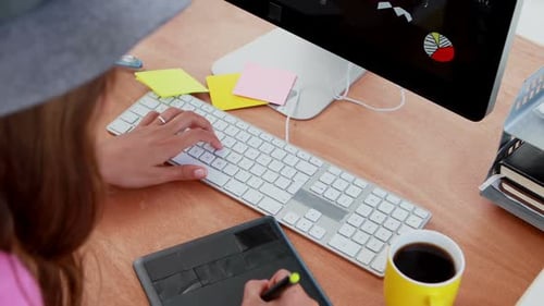 Woman Designs with Tablet and Keyboard on Desk