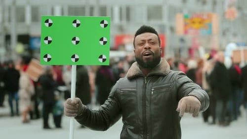 Adult Male Demonstrator at Urban Rally with Green Sign