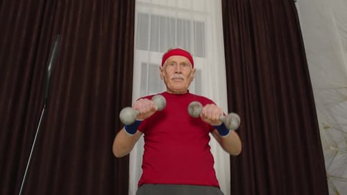 Active Senior Man Lifting Dumbbells at Home