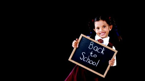 Smiling Schoolgirl Holds Back to School Sign