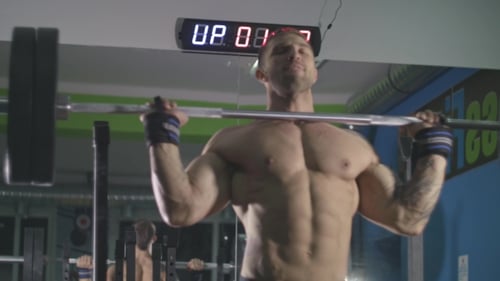Athlete Trains with a Barbell