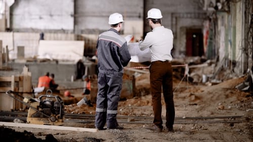 Engineers Reviewing Blueprint at Construction Site