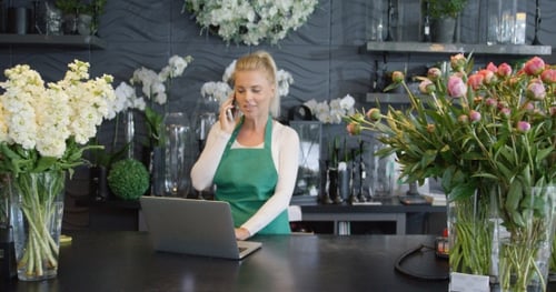 Woman Talking Phone in Floral Shop