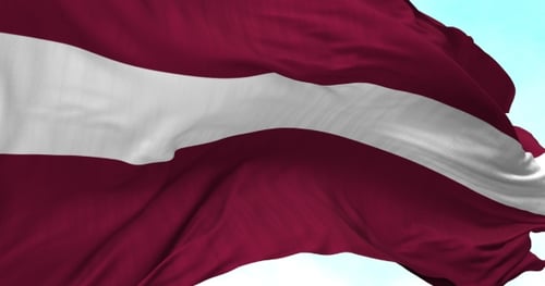 Flag of Latvia Waving in Slow Motion Against Blue Sky