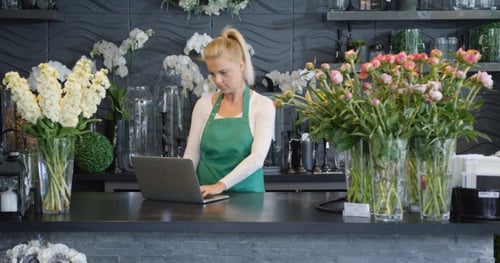 Woman with Laptop in Floral Shop