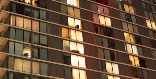 Illuminated Building at Night, Windows with Silhouettes