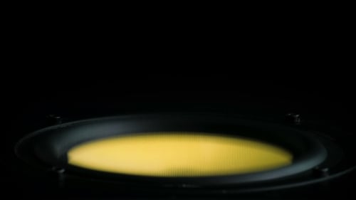 Speaker Vibrating Yellow Audio in Darkness