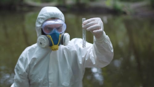 Scientist in Hazmat Suit Testing Water Sample
