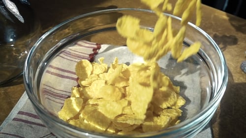 Cornflakes Poured Into Clear Glass Bowl for Breakfast