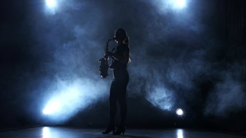 Instrumentalist Woman Plays on Wind Instrument Saxophone Melody. Smoky Studio